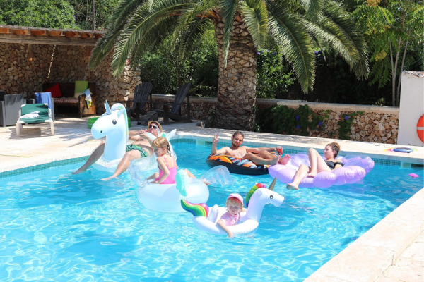 Photo of Taylor family relaxing on inflatables in pool 